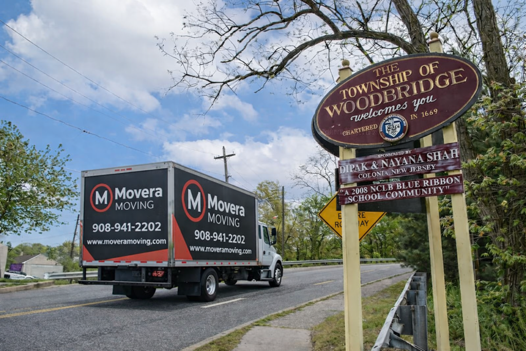 Woodbridge NJ movers truck near Woodbridge township sign